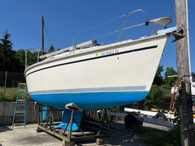 1992 Hunter 30-2 sailboat on dry dock, blue hull, clear sky background.