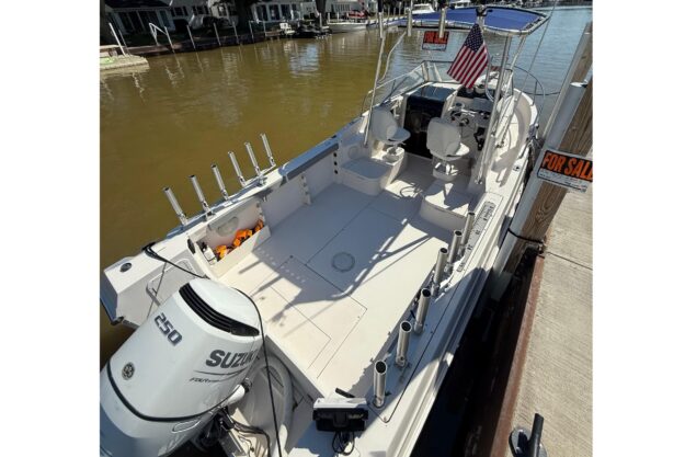 1993 Aquasport 225 Explorer boat with Suzuki engine, docked and for sale.