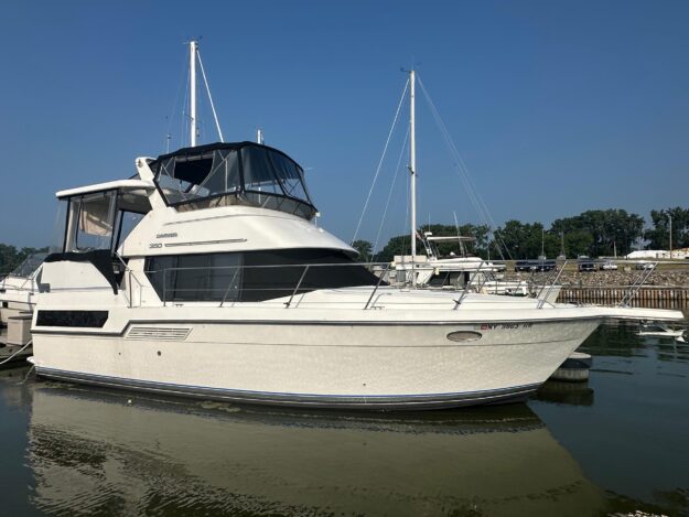 1993 Carver 350 Aft Cabin yacht docked in a marina under clear blue skies.