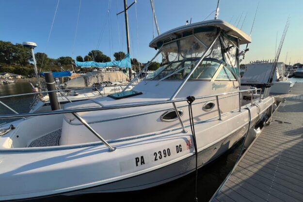 1994 Pro-Line 2950 boat docked at marina, sunny day, fishing rods visible.