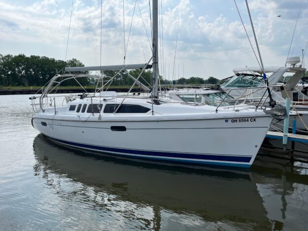 2000 Hunter 340 sailboat docked in a marina under a cloudy sky.