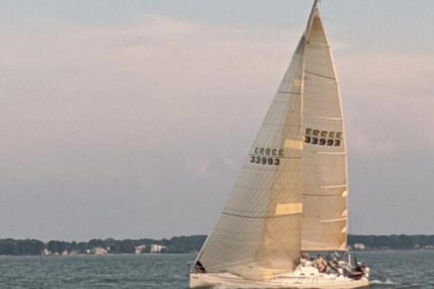 Sailing yacht Beneteau First 40.7, 2001 model, gliding on calm waters at sunset.