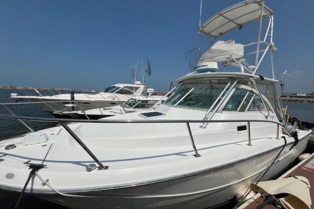 2001 Rampage Express 30 Open boat docked at marina under clear blue sky.