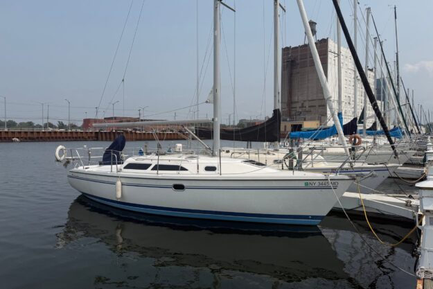 Sailboat Catalina 28 MkII 2003 docked in marina, calm water, urban backdrop.