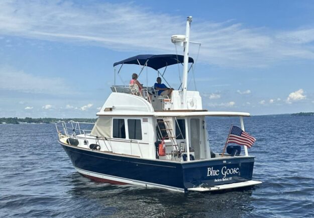 2003 Sabre 36 Fly Bridge Sedan boat on water, featuring “Blue Goose” name and American flag.