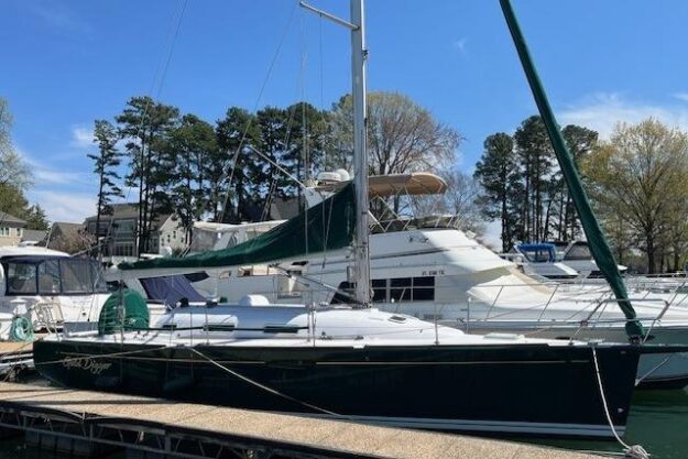 Sailboat docked at marina, Beneteau First 36.7, 2005 model, clear sky background.