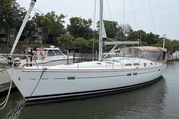 2007 Beneteau 423 sailboat docked in a marina, surrounded by trees and other boats.