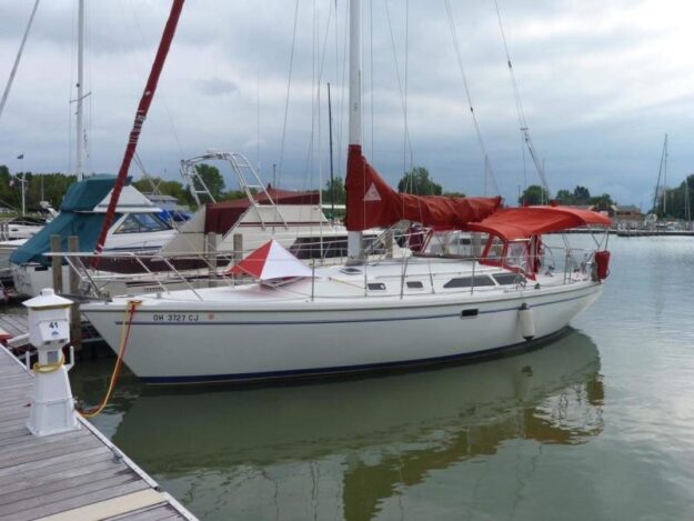 1999 Catalina 36 Mark II sailboat docked at a marina with red sail covers.