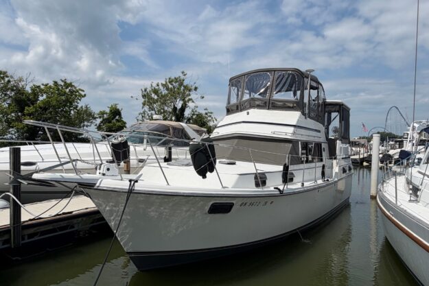 1989 Carver 3607 Aft Cabin Motor Yacht docked at marina under cloudy sky.