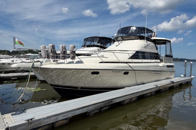 1990 Silverton 41 Aft Cabin yacht docked on a sunny day with clear skies.
