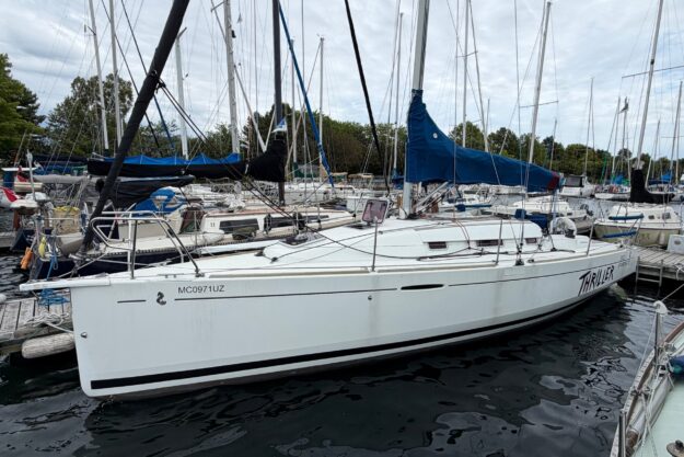 2011 Beneteau First 30 sailboat docked in a marina, surrounded by other boats.