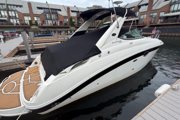 2013 Sea Ray Sundancer 280 docked at a marina with modern architecture in the background.