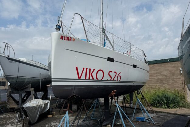 Sailboat Viko S26 2019 model on stands, displayed outdoors under cloudy sky.
